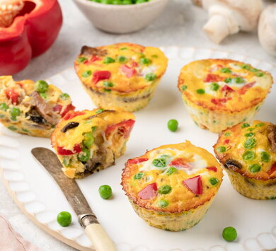 Muffins aux œufs pour le petit-déjeuner avec poivrons, champignons, pois verts et fromage