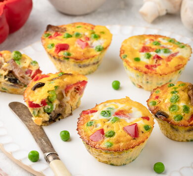 Breakfast egg muffins with bell peppers, mushrooms, green peas and yellow cheese