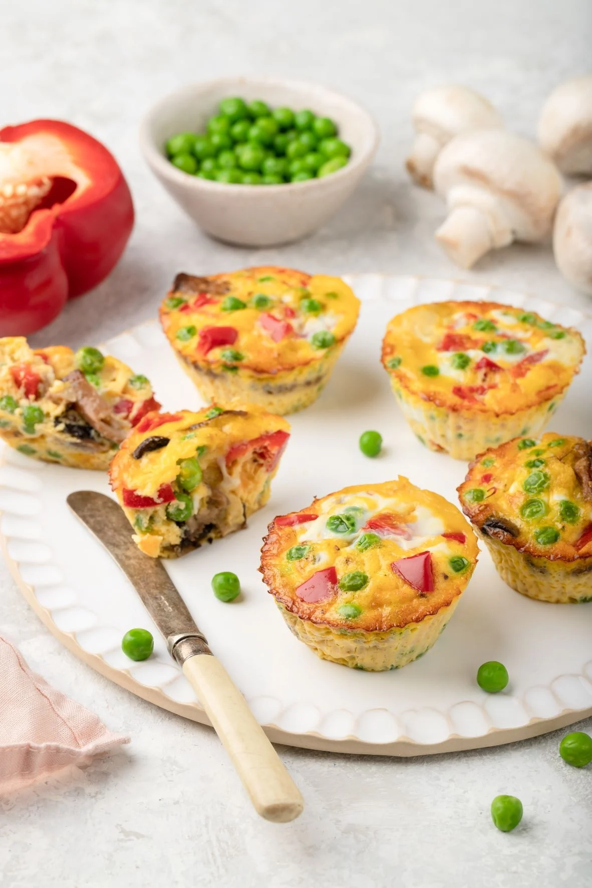 Muffins aux œufs pour le petit-déjeuner avec poivrons, champignons, pois verts et fromage 